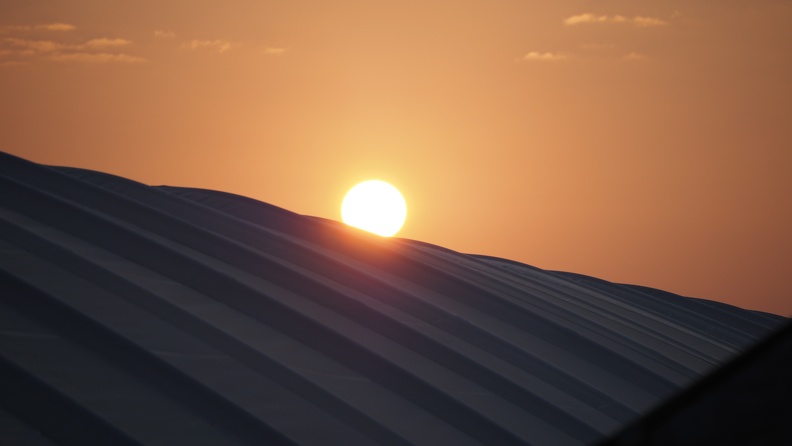 Sonnenaufgang über dem großen Plastikplanengewächshaus